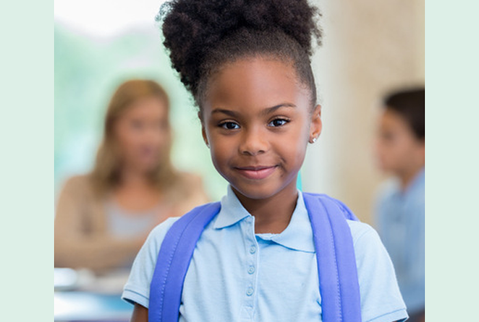 young black girl with backpack smiling