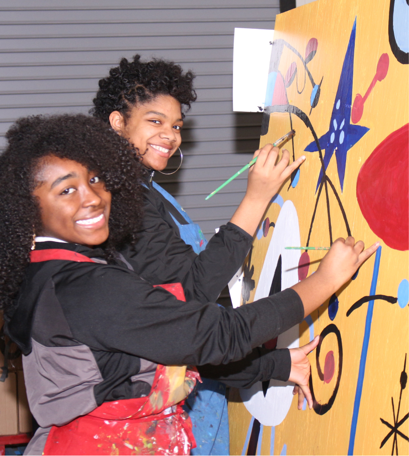 two girls paining a canvas\ at university academy charter school.